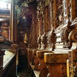 Drewniane fotele dla księży, w bazylice w Kalwarii Zebrzydowskiej. Bogato zdobione płaskorzeźbami. Z wysokim tyłem, daszkiem wspartym na kolumnach i z klęcznikami.