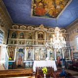 Wnętrze drewnianej cerkwi. Bogate polichromie i ikonostas.