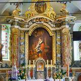Bogato zdobiony ołtarz główny we wnętrzu kościoła z licznymi złoceniami i obrazem świętej Katarzyny. Pod obrazem tabernakulum i po bokach wysokie świece. Po lewej i prawej figura i za nimi wysokie okna z witrażami.
