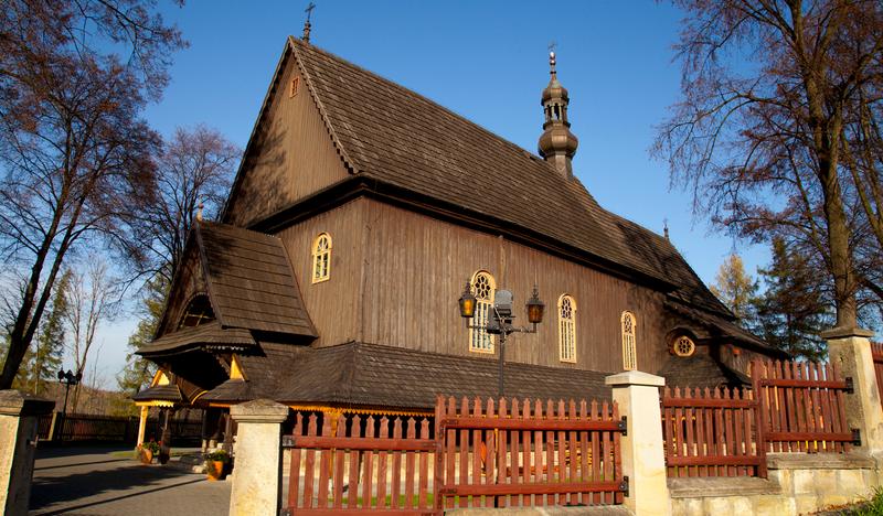 Zdjęcie przedstawiające zabytkowy, drewniany kościół.