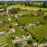Zdjęcie przedstawia winnicę święty spokój widzianą z lotu ptaka. Widoczna część gospodarstwa to główne budynki, pole z krzewami winogron oraz ogród.