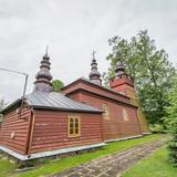 Drewniana cerkiew z wieżą i blaszanym dachem.