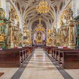 Wnętrze kościoła w jasnej kolorystyce, ołtarze boczne i główny, ławy, złocenia.