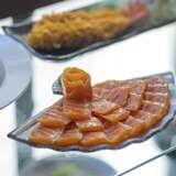 Kawałki łososia na talerzu w kształcie wachlarza w Restauracji Hana Sushi w Krakowie.