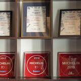 Półka z nagrodami Michelin oraz Restaurant Week Restauracji Hana Sushi w Krakowie.