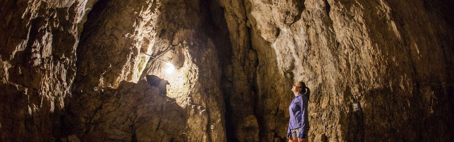 Sala w jaskini, turystka oglądająca nacieki.