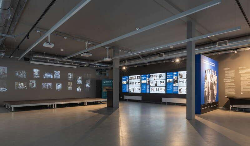 Fragment multimedialnej wystawy muzealnej, zdjęcia wyświetlane na ścianach.