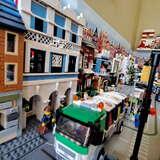 na pierwszym planie śmieciarka z klocków LEGO, w dalszej części budynki i inne pojazdy z klocków