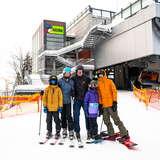 Zdjęcie z pozującymi narciarzami i snowboardzistami przed górną stacją wyciągu krzesełkowego ośrodka Kasina-Ski w Kasinie Wielkiej.