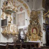 Wnętrze kościoła z barokowym wystrojem, amboną, ołtarzem bocznym i ławami.
